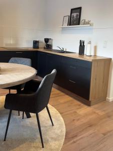 a kitchen with a table and a sink and a table and chairs at Belm Ferienwohnung am Bach in Belm