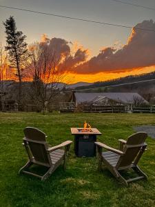 two chairs and a picnic table in a field at Petite Retreat in West Jefferson