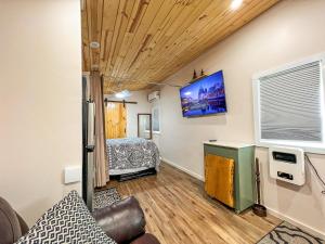 a room with a bed and a tv on the wall at Petite Retreat in West Jefferson