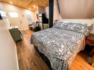 a bedroom with a bed with a black and white comforter at Petite Retreat in West Jefferson