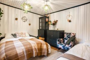 a bedroom with a bed and a chair at Le Chalet Bed&Bath -Chez Les Alfreds in Soubey