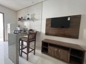 uma cozinha com um balcão com uma cadeira e uma televisão em Bahia Trip Flats em Lençóis