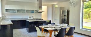 a kitchen with a table and chairs and a kitchen with a refrigerator at Casa Finca Jaccuzi Aire Acondicionad Wifi TV in Ricaurte
