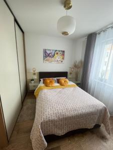 Un dormitorio con una cama con una manta. en Apartament NOWE POJEZIERZE en Olsztyn