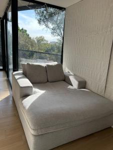 ein Sofa in einem Zimmer mit einem großen Fenster in der Unterkunft Residencial Chicle D401 in Mexiko-Stadt