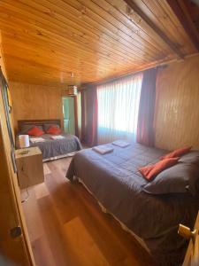 a bedroom with two beds and a wooden ceiling at El Fogon de Rio Claro in Rio Claro