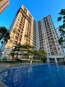 a swimming pool in front of two tall buildings at Apartemen Serpong Green View by Heaven Rooms in Ciater-hilir