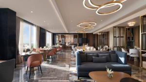 斋浦尔InterContinental Jaipur Tonk Road by IHG的一间带沙发和桌椅的餐厅