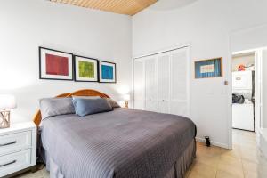 a bedroom with a bed and a white wall at Turtle Bay Townhouse Steps to Our Beautiful Beach! in Kahuku