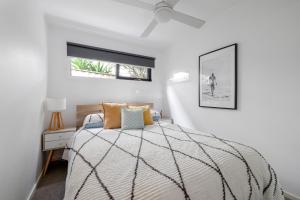 a white bedroom with a bed and a window at Halcyon Days in San Remo