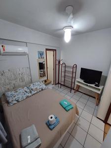een kleine slaapkamer met een bed en een televisie bij Apto Centro Floripa 01 com Garagem in Florianópolis