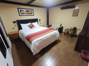 a bedroom with a large bed and a chair at La Posada del Viajero in Cusco