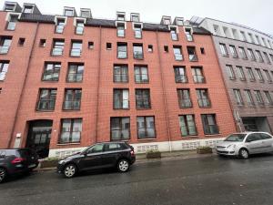 two cars parked in front of a brick building at Uferzauber, Wohnung an der Schlachte, Innenstadt, Bremen in Bremen