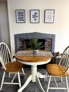 a table with two chairs and a potted plant on it at The Hideaway Holywell 1 in Holywell