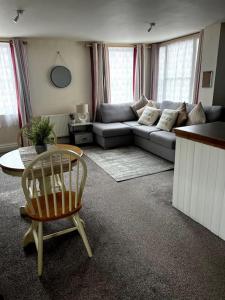 a living room with a couch and a chair at The Hideaway Holywell in Holywell