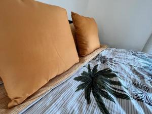 a bed with two pillows and a palm tree on it at The Hideaway Holywell in Holywell