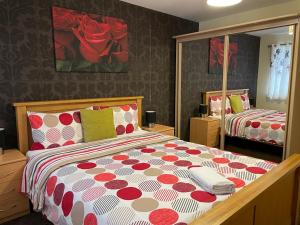 a bedroom with a bed with a red and white comforter at Falconwood Apartment in Manchester