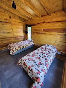 サンタ・ロサ・デ・カラムチタにあるSueño Serranoの丸太小屋のベッドが2つある寝室 +24枚の写真