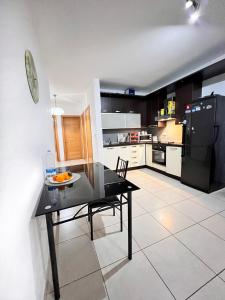 une cuisine avec une table noire et un réfrigérateur noir. dans l'établissement Lovely Home, à Il-Gżira