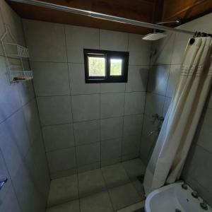 a bathroom with a shower and a sink and a window at Sueño Serrano in Santa Rosa de Calamuchita +24 photos
