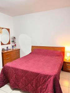 - une chambre avec un lit et une couverture rouge dans l'établissement Lovely Home, à Il-Gżira