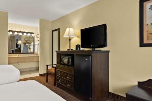 Best Western Center Pointe Inn في برانسون: غرفة فندق بسرير وتلفزيون على دولاب