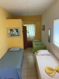 - une chambre avec 2 lits dans une chambre avec une fenêtre dans l'établissement Pousada Sol da Ilha, à Igrapiúna