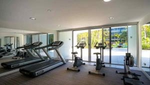 a gym with a bunch of treadmills and ellipticals at 2BR Resort Living: 2-Bed Haven in Gold Coast