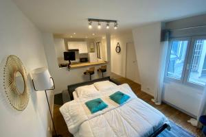 een slaapkamer met een bed met twee blauwe kussens bij Cozy haven of peace ideal for a romantic stay in Saint-Mandé
