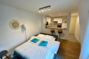 een slaapkamer met een wit bed met blauwe kussens bij Cozy haven of peace ideal for a romantic stay in Saint-Mandé