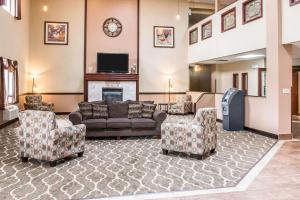 sala de estar con sofá, sillas y chimenea en Country Inn & Suites by Radisson, Battle Creek, MI, en Battle Creek