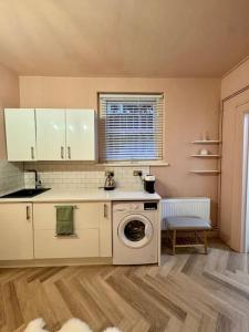 a kitchen with a washer and a washing machine at The Studio at Athol House in London