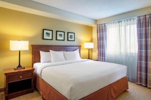 a large bed in a hotel room with two lamps at Country Inn & Suites by Radisson, Winnipeg, MB in Winnipeg