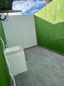 テキーラにあるCasa Landeros y Osunaの緑と白の壁の客室で、椅子が備わります。