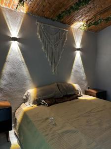 テキーラにあるCasa Landeros y Osunaのベッドルーム1室(壁に照明付きのベッド1台付)
