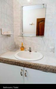 a bathroom with a white sink and a mirror at Private Room in Urdesa Central Guayaquil in Guayaquil