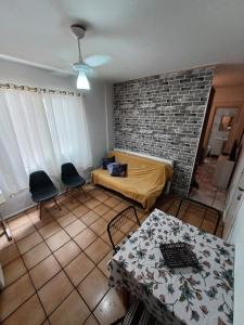 a living room with a bed and a brick wall at Apto Centro Floripa 03 in Florianópolis