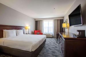 a hotel room with a bed and a flat screen tv at Country Inn & Suites by Radisson, Tucson City Center AZ in Tucson