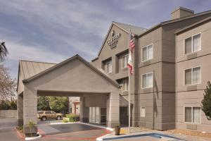 a front view of a hotel with an american flag at Country Inn & Suites by Radisson, Fresno North, CA in Fresno