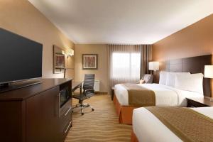 a hotel room with two beds and a flat screen tv at Park Inn by Radisson Toronto-Markham in Markham