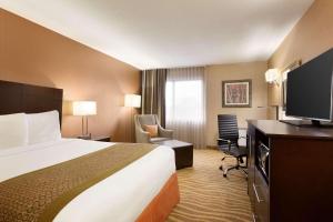 a hotel room with a bed and a flat screen tv at Park Inn by Radisson Toronto-Markham in Markham