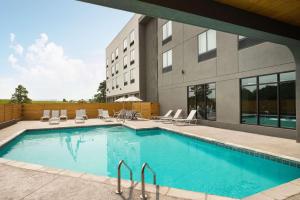 einem Pool vor einem Gebäude in der Unterkunft Radisson Hotel West Memphis in West Memphis