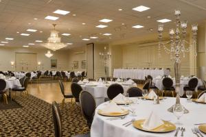 um salão de banquetes com mesas e cadeiras brancas em Park Inn By Radisson Sharon em West Middlesex