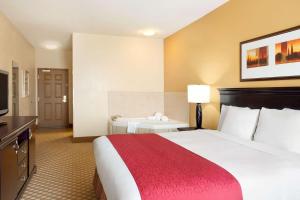a hotel room with a large bed with a red blanket at Country Inn & Suites by Radisson, Conway, AR in Conway +21 photos