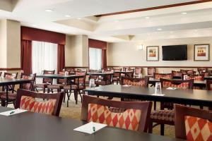 a restaurant with tables and chairs and a flat screen tv at Country Inn & Suites by Radisson, Conway, AR in Conway