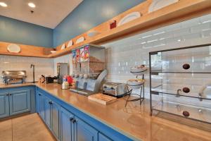 a large kitchen with blue cabinets and a counter at Country Inn & Suites by Radisson Ocala Southwest in Ocala