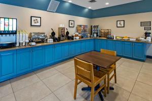 een keuken met blauwe kasten en een houten tafel bij Country Inn & Suites by Radisson, Salisbury, MD in Salisbury