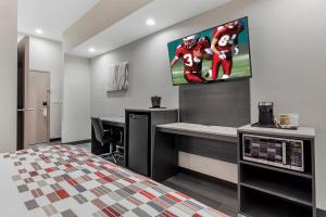 a bedroom with a football game on the wall at Red Roof Inn Hutchins in Hutchins
