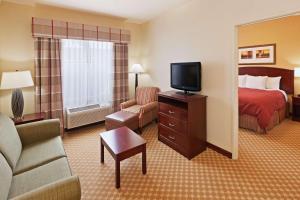 a hotel room with a bed and a flat screen tv at Country Inn & Suites by Radisson, Tulsa, OK in Tulsa