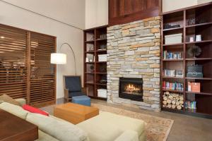 a living room with a fireplace and a couch at Country Inn & Suites by Radisson, Madison West, WI in Middleton